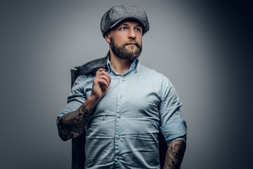 Bearded male in a shirt and tweed cap.