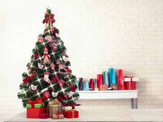 Christmas tree with present boxes over white brick wall