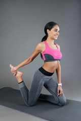 Fototapeta premium Muscular happy woman using fitness mat