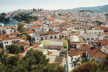 Fototapeta na wymiar Look from above at beautiful Greek city in the rays of summer li
