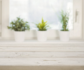 Wooden table on blurred winter window with plant pots background