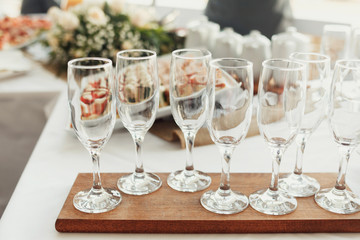 Empty champagne flutes stand on wooden board
