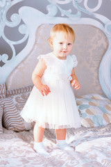 happy little girl in white dress standing in the Christmas decorated room