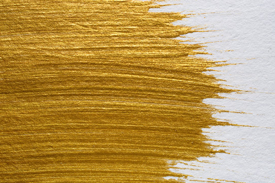 Gold acrylic paint on white paper background , gold texture free