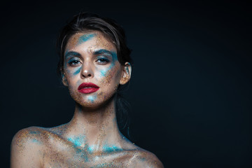 Beauty portrait of gorgeous young woman with blue glitter makeup