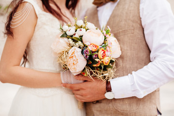 Obraz na płótnie Canvas newlyweds holding wedding bouquet