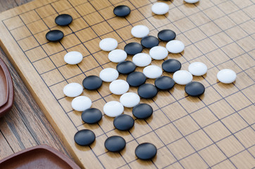 Obraz na płótnie Canvas Chinese board game go with black and white stones