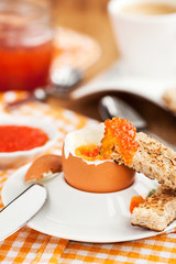 Boiled egg with red caviar, toast and coffee