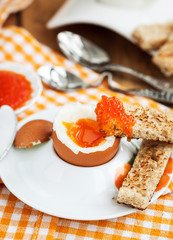 Boiled egg with red caviar, toast and coffee