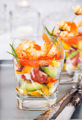 Shrimp, avocado, tomato, salmon and red caviar cocktail salad in