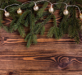 christmas square composition with vintage garland and fir branches on wooden background. string lights.