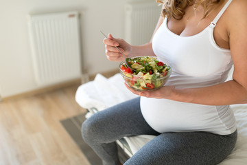 Pregnant woman eating healthy salad