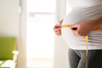 Pregnant woman measuring belly diameter