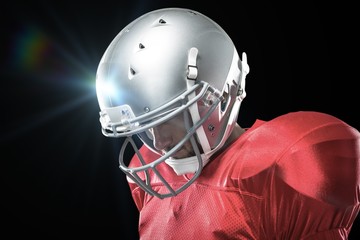 Composite image of american football player looking down