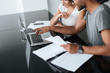 Cropped photo of loving young couple analyzing their finances