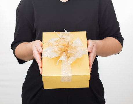 Women holding gold christmas gift box