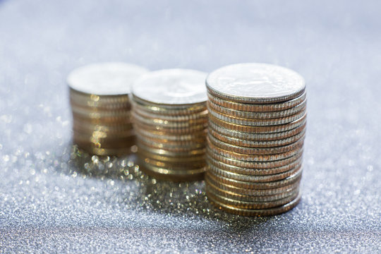 Selective focus of stack of US. dollar coins with silver glitter