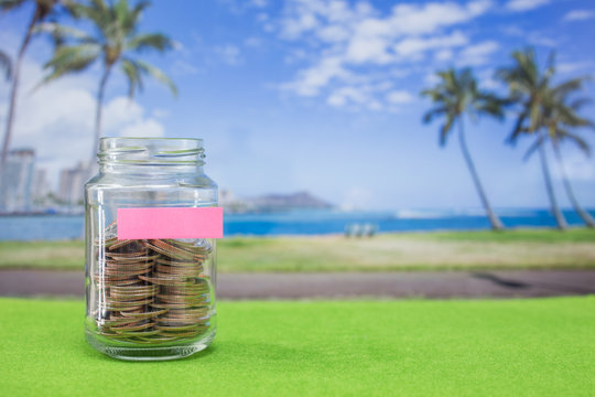 Coins in bottle with island background use for travel programe