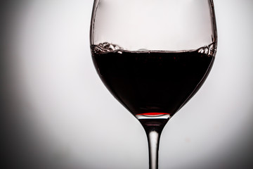 Naklejka na ściany i meble Dark red wine in glass filled it half