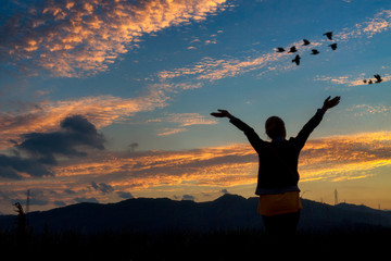 Woman and travel enjoying nature on sunset sky background.