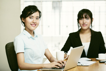Fototapeta premium Beautiful young businesswomen working and typing