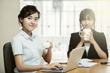 Beautiful young businesswomen working and enjoy drinking coffee
