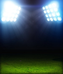Green soccer field, bright spotlights, illuminated stadium © Kalawin