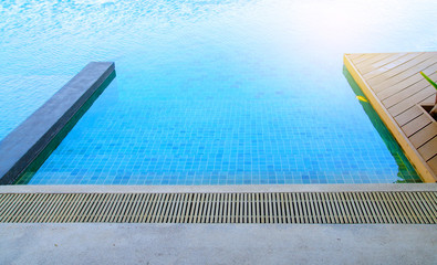 Outdoor swimming pool with blue water near the garden.