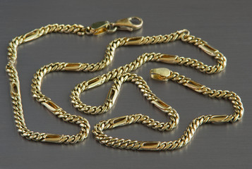 Gold chain on the aluminium background