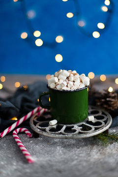 Cocoa with marshmallows in a mug on a background of lights