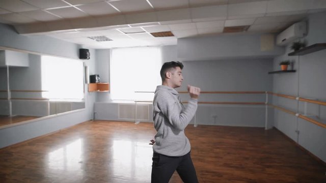 The dance teacher in the hall for rehearsals. He does the slow and smooth movements, thus working all movements in the dance contemporary.