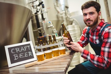 Portrait of manufacturer examining beer