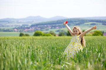 Little girl in cornfield with wide open arms. Child relaxing and