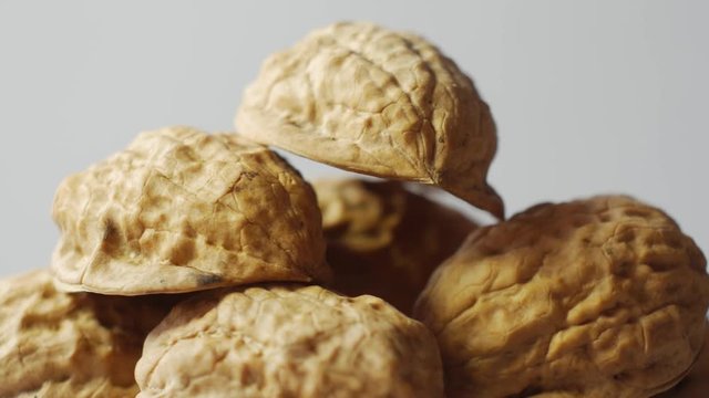 Macro pile of walnuts isolated on white, rotates around.