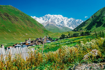 Naklejka premium Village Ushguli landscape with massive rocky mountains (Bezengi wall, Shkhara) on the background in Svaneti, Georgia