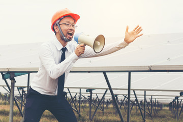 engineer working on checking and maintenance equipment at solar power plant ; engineer bawling with Megaphone at outdoor 