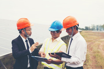 engineer working on checking and maintenance equipment at industry solar power; two engineer and technician discussion plan to find problem of solar panel