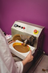 Worker filling mould with melted chocolate