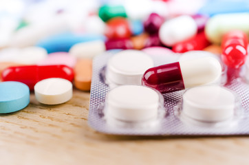 Multicolored Capsules and Pills Lying on a Wooden Surface. Closeup