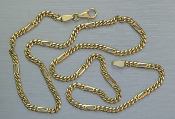 Gold chain on the aluminium background