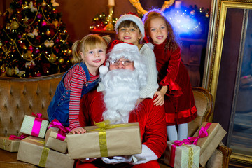 Fototapeta na wymiar Santa Claus and group of girls with Christmas gifts
