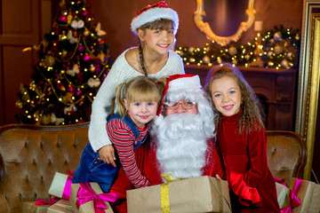 Santa Claus and group of girls with Christmas gifts