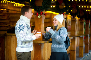 Cute young couple has a good time at the Christmas bazaar.