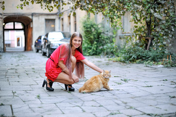 Portrait of beautiful woman model with a cat in the garden

