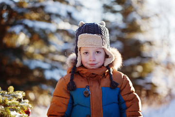 Portrait of a boy walking in the winter nature. Playing with snow. Concept happy childhood