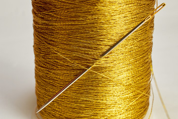 needle stuck in spool gold thread