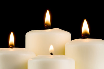 Fototapeta na wymiar Weisse brennende Kerzen im dunklen