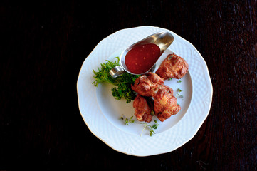 grilled chicken wings with spicy tomato sauce in white plate