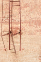 simple metal ladder on cement wall with soft shadow. Architectural background
