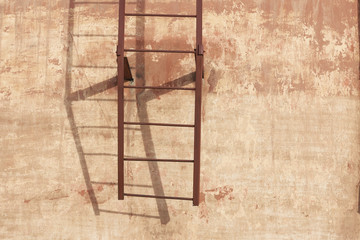 simple metal ladder on cement wall with soft shadow. Architectural background